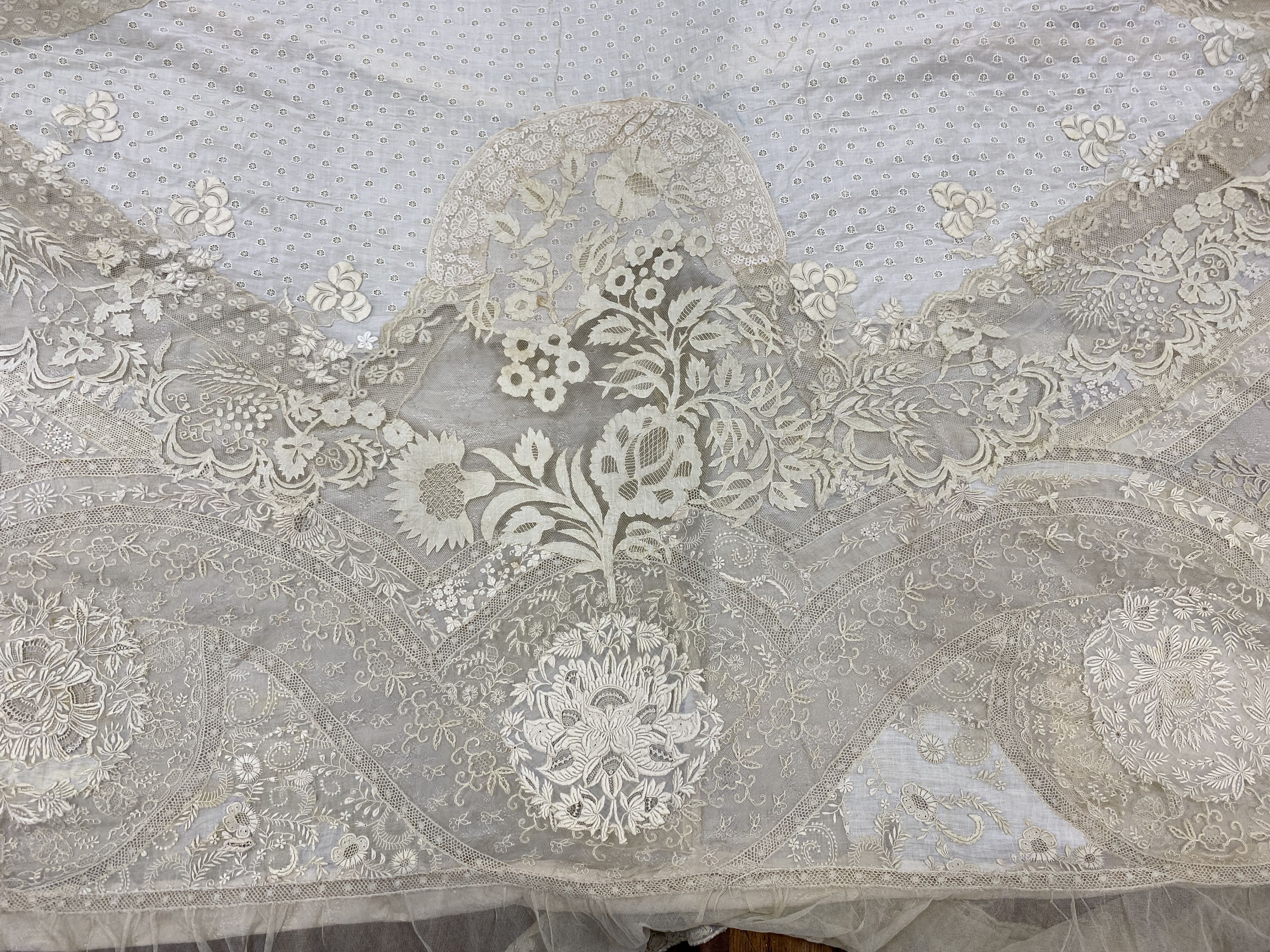 An Edwardian hand made lace bedspread. Hand sewn using finely spun lawn, decorated with Carrickmacross and white work embroidery, edged in bobbin lace. Possibly made as part of a trousseau.